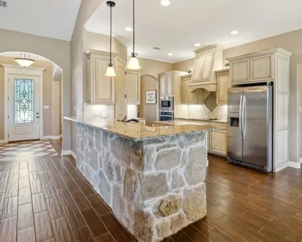 off white or beige kitchen cabinets and walls with white trim and stone island with solid surface countertop by Bear Creek Painting, Inc.